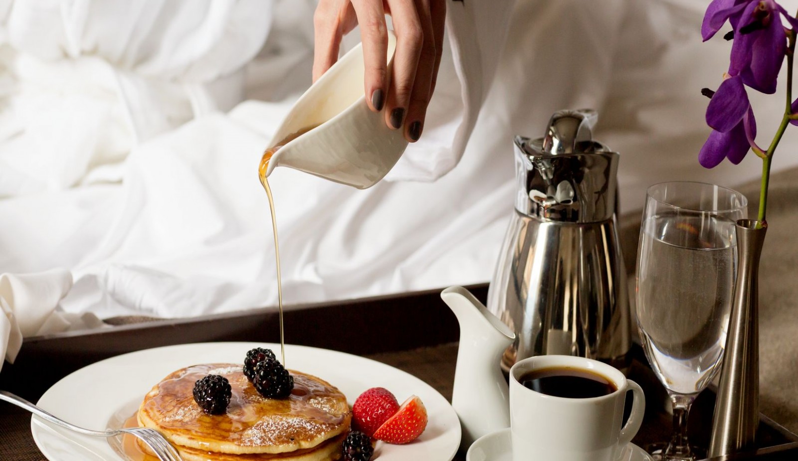 Breakfast in bed with our famous three stacked pancakes with thick organic maple syrup.