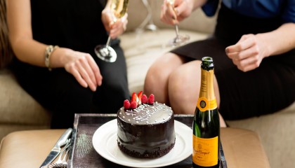 A chocolate Happy Birthday Cake alongside a bottle of champagne. This is part of our Birth Celebration Package on our website.