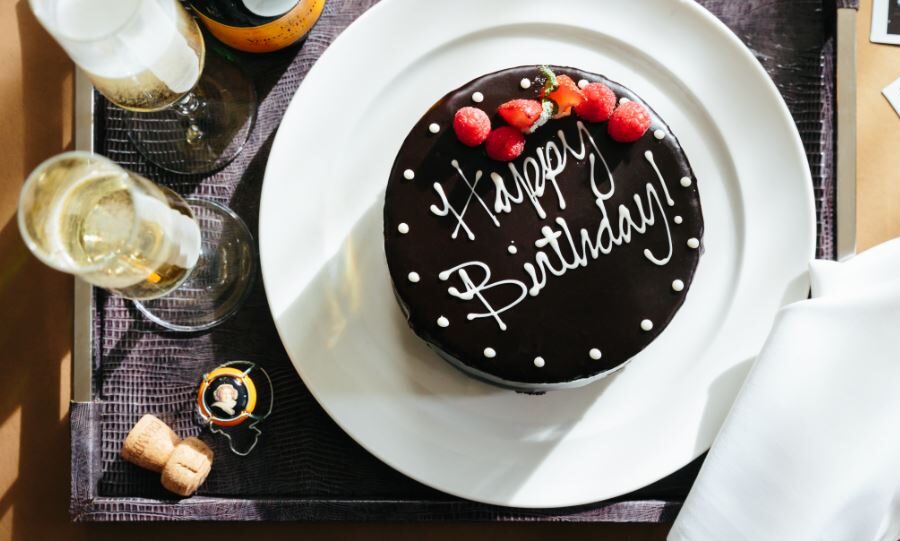 A chocolate Happy Birthday Cake alongside a bottle of champagne. This is part of our Birth Celebration Package on our website.
