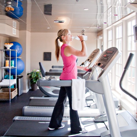 Photograph if a beautiful woman working out on our treadmil machine in our 24/7 fitness center.