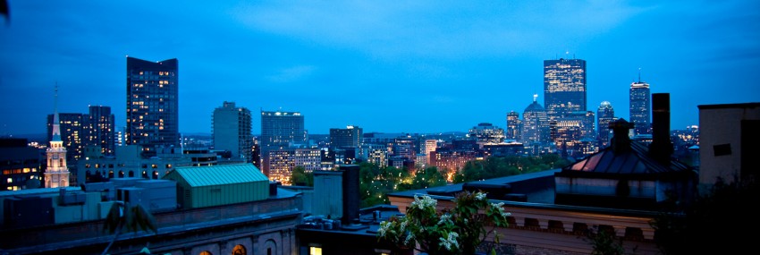 Fifteen Beacon's view from our roof deck overlooking Boston's building after dark.