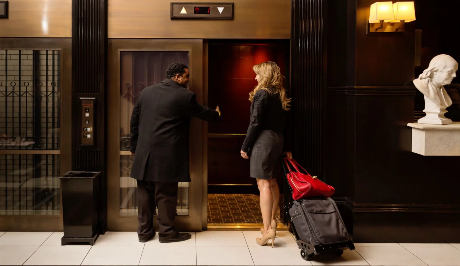 One of our bellman assistance a young lady into our 1903 historic elevators.
