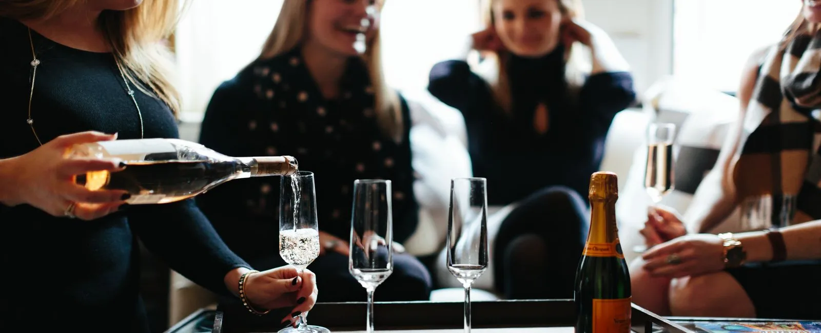 Four young lady celebrating with a champagne toast.
