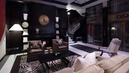 The hotel's lobby featuring a fireplace, casual sitting for guests, and access to the guest elevators and original stair case that dates back to 1903