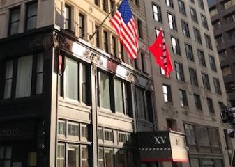 Exterior of the hotel from the street level along with the Fifteen Beacon Logo flag and American Flag