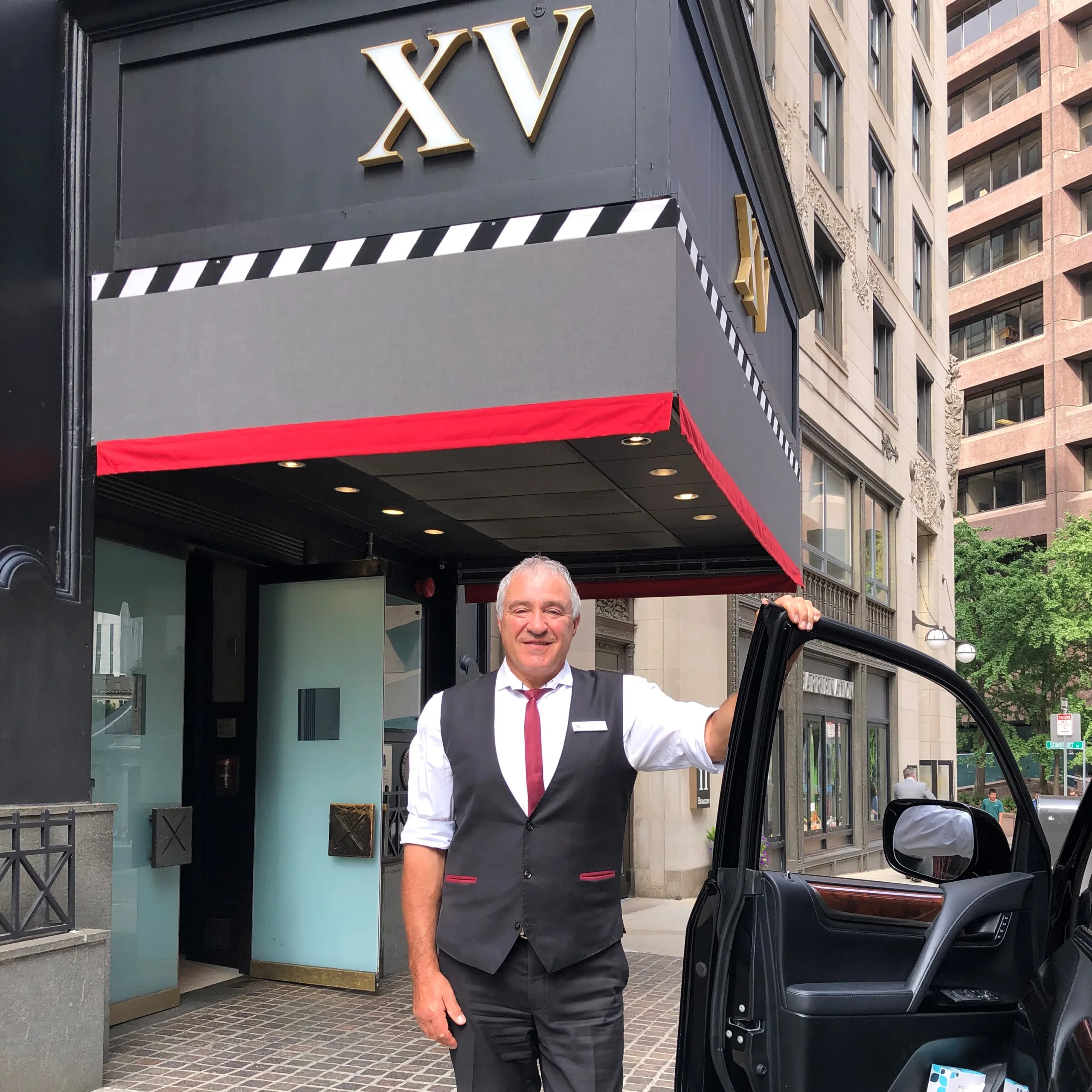 male hotel employee standing outside of the XV Beacon Hotel
