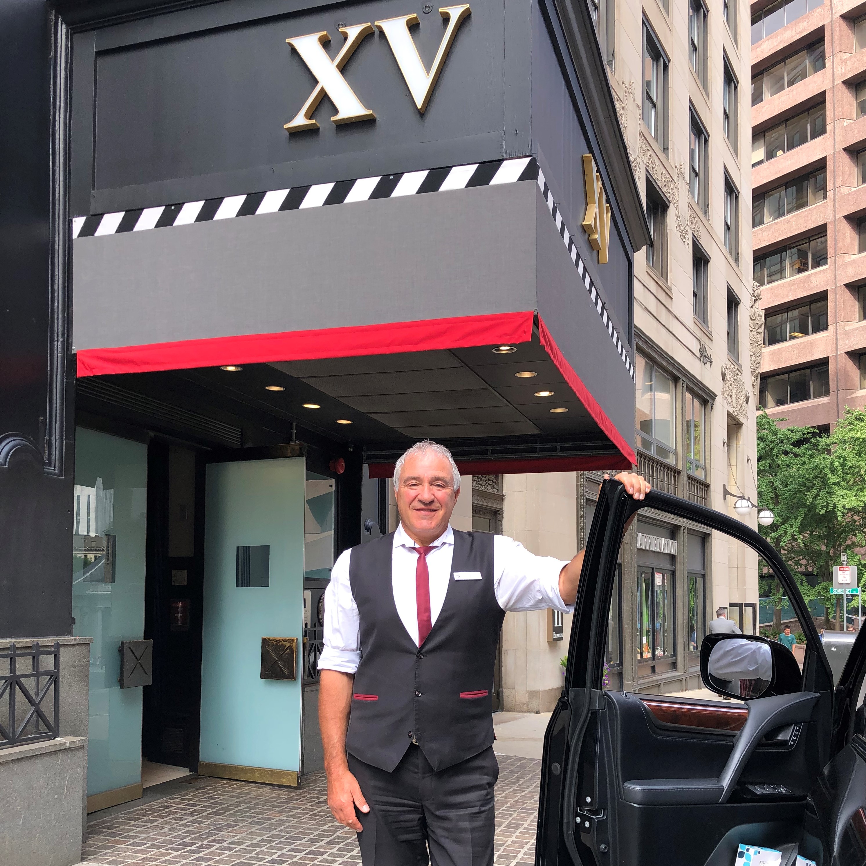 male hotel employee standing outside of the XV Beacon Hotel