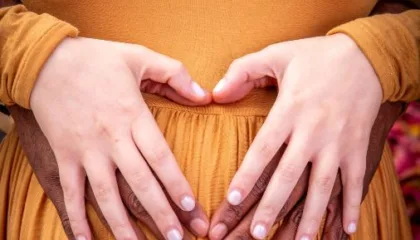 picture of mother to be and father to be's hand on the mothers belly