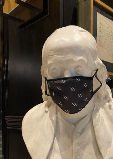 Photo of the Ben Franklin statue in our lobby with a COVID-19 mask on