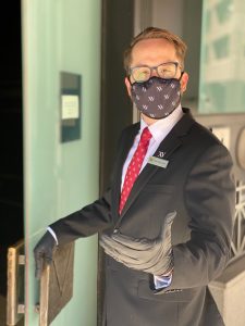 Employee welcoming you to XV beacon wearing a face mask