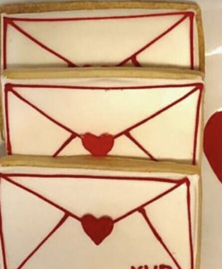 Photo of XV Beacon's Valentines Day Cookies with a small box of chocolates with a red ribbon