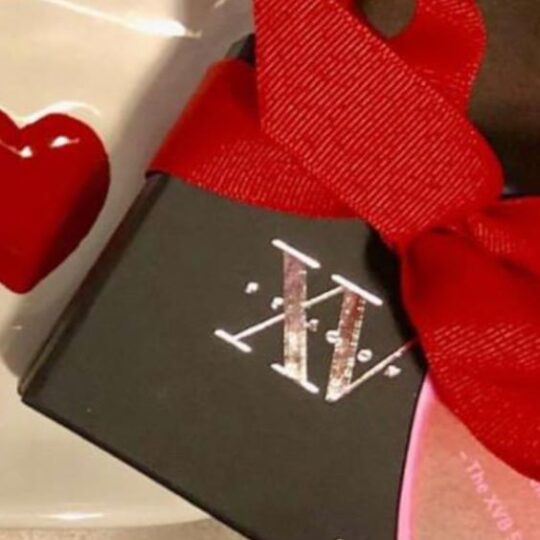 Photo of XV Beacon's Valentines Day Cookies with a small box of chocolates with a red ribbon